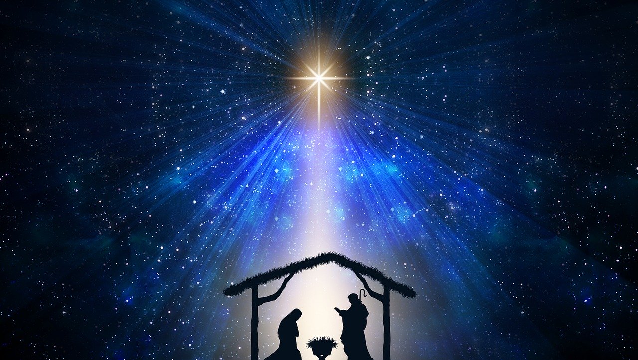 A silhouette of the nativity with a bright star above it